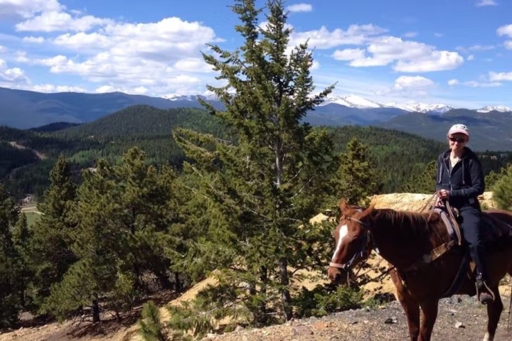 a man riding a horse with a mountain in the background